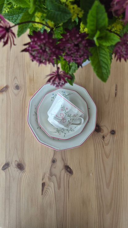 Churchill-porslinsservis med tekanna och kopp, omgivet av lila blommor på träbord